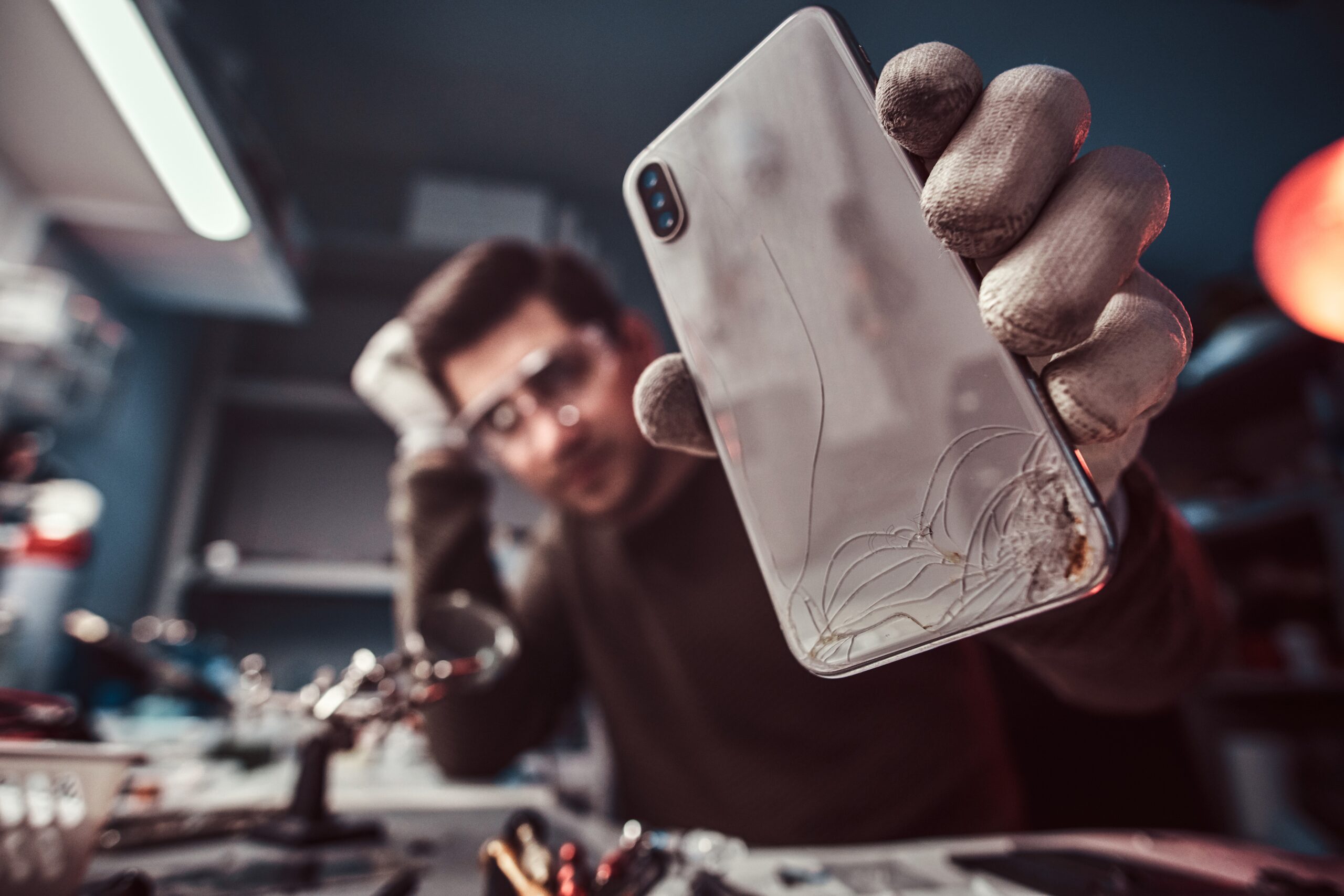 electronic technician repair damaged smartphone in the workshop